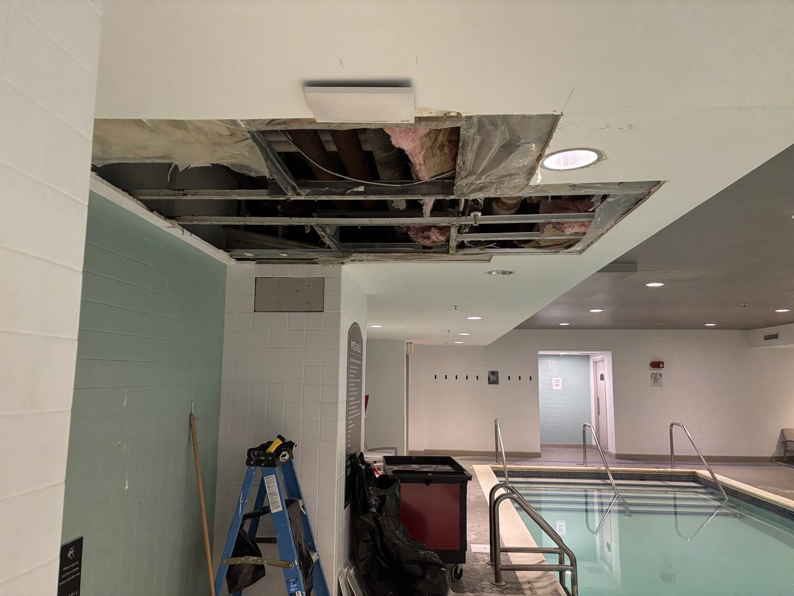 Pool-area ceiling with water damage and open framing