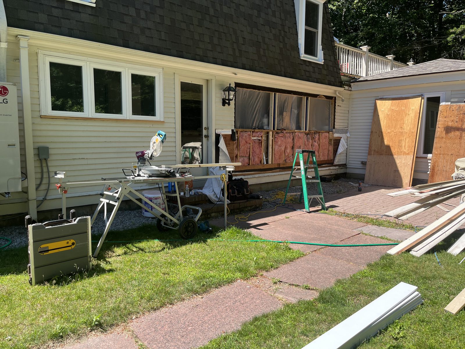 Home exterior mid-renovation, sheathing exposed