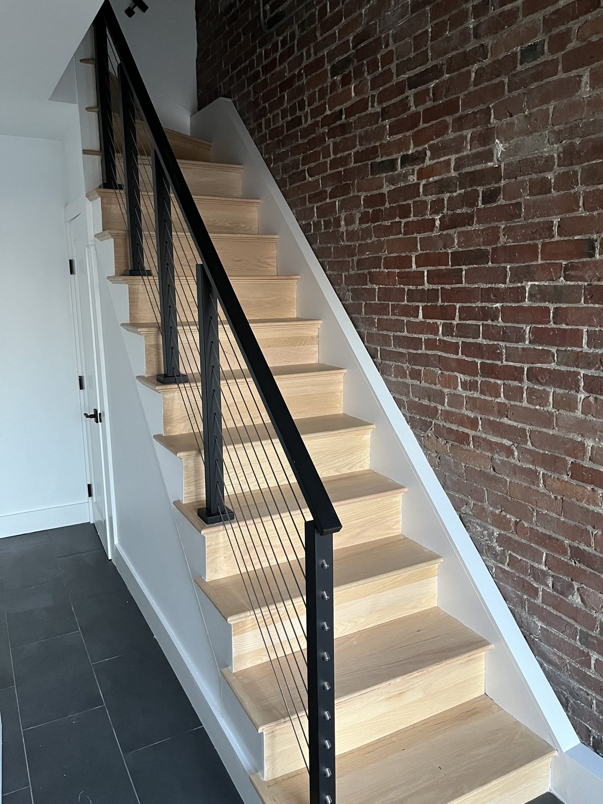 Custom staircase with cable railing and exposed brick